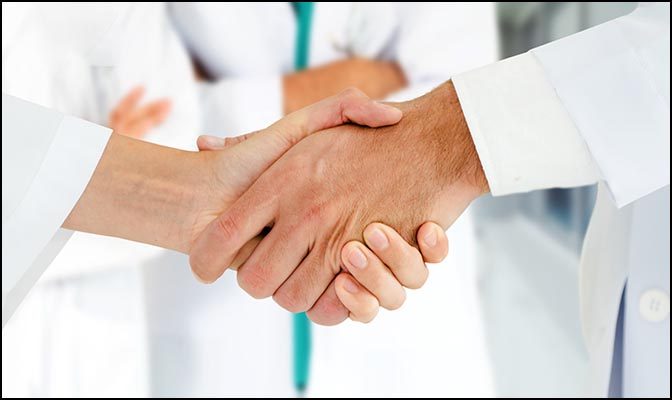 a handshake and white lab coats