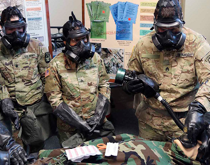 three soldiers wearing gas masks